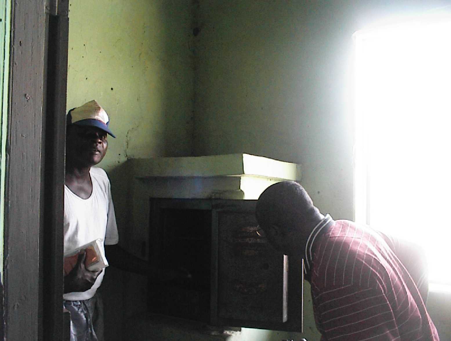 The custodian walking Njoku through the mission house.  Here, Njoku inspects the first safe in Badagry, Lagas.
