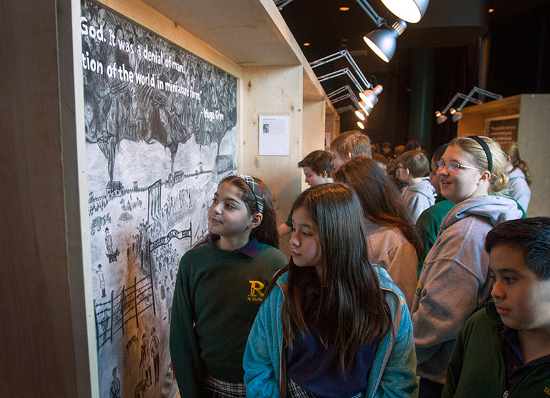 Students examine the VAMPY Holocaust murals during an exhibition at The Kentucky Center for the Performing Arts in Louisville. The murals were displayed in conjunction with performances of the play 