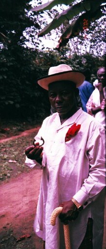 A chief holding an item that was used as currency in the slave trade