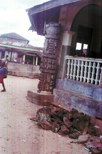 A wooden portal of different figures in front of Ndi Odo hall
