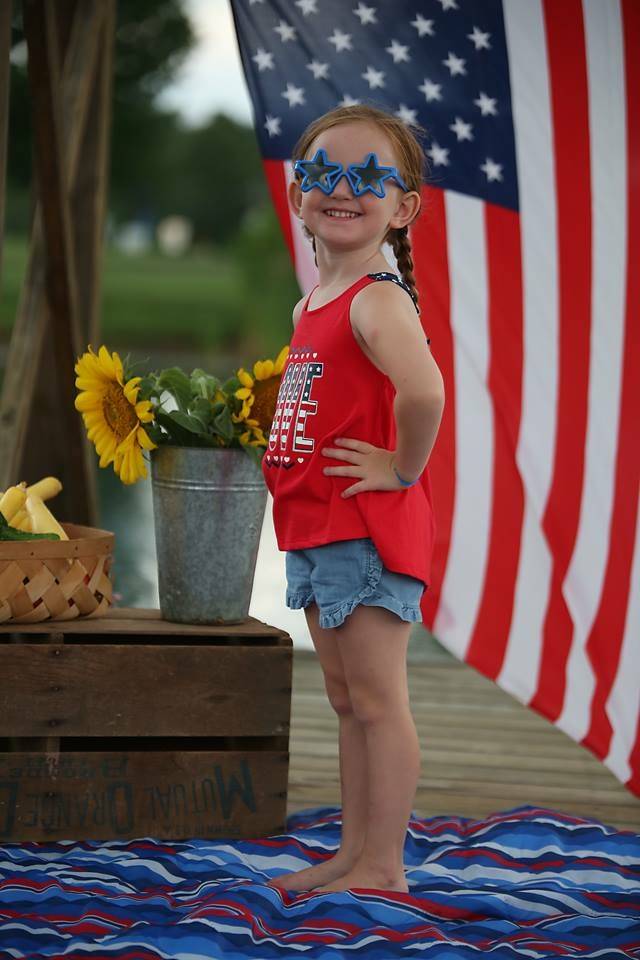 little girl with blue star shaped sunglasses