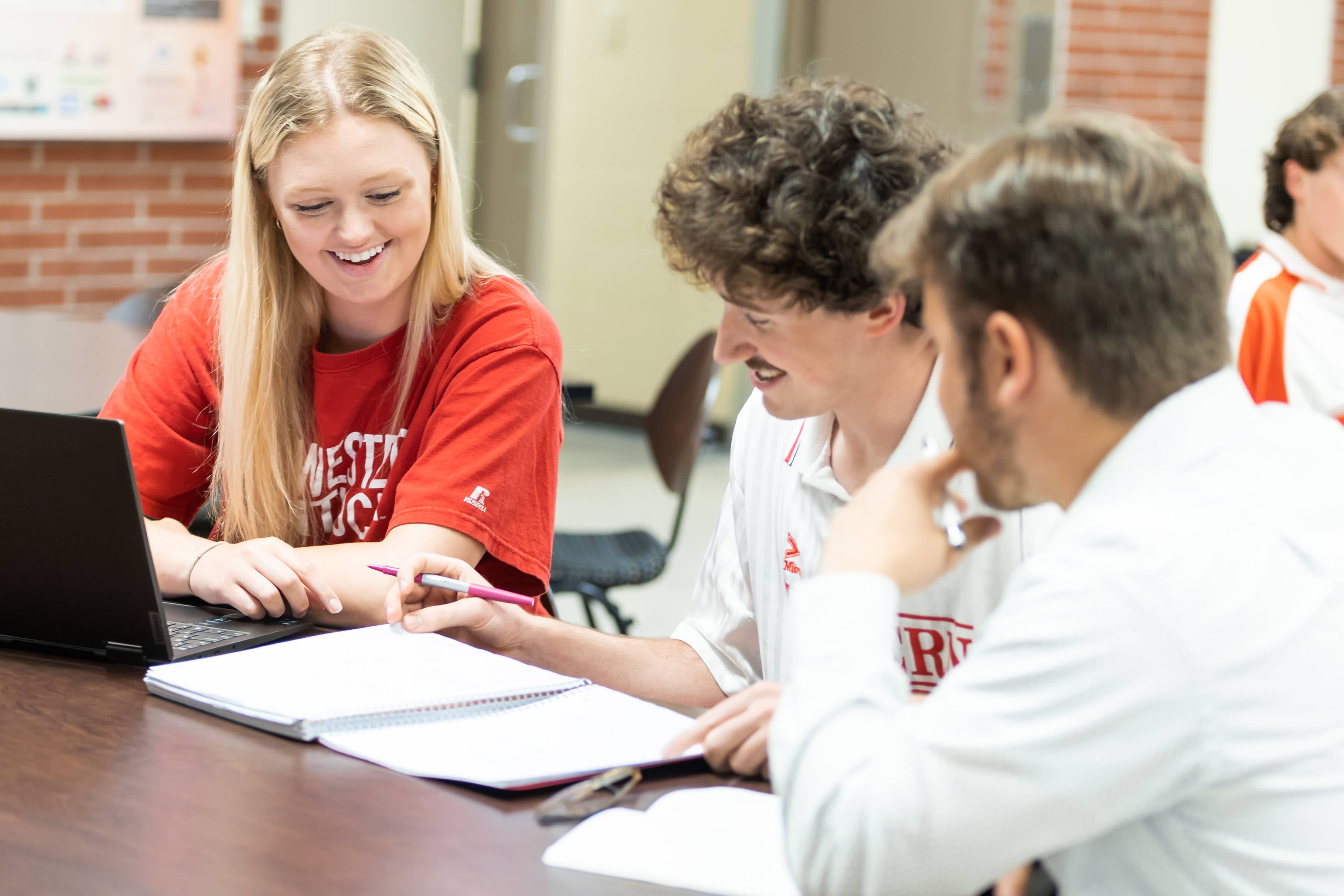 Three students sit at a table and work together in Grise Hall.