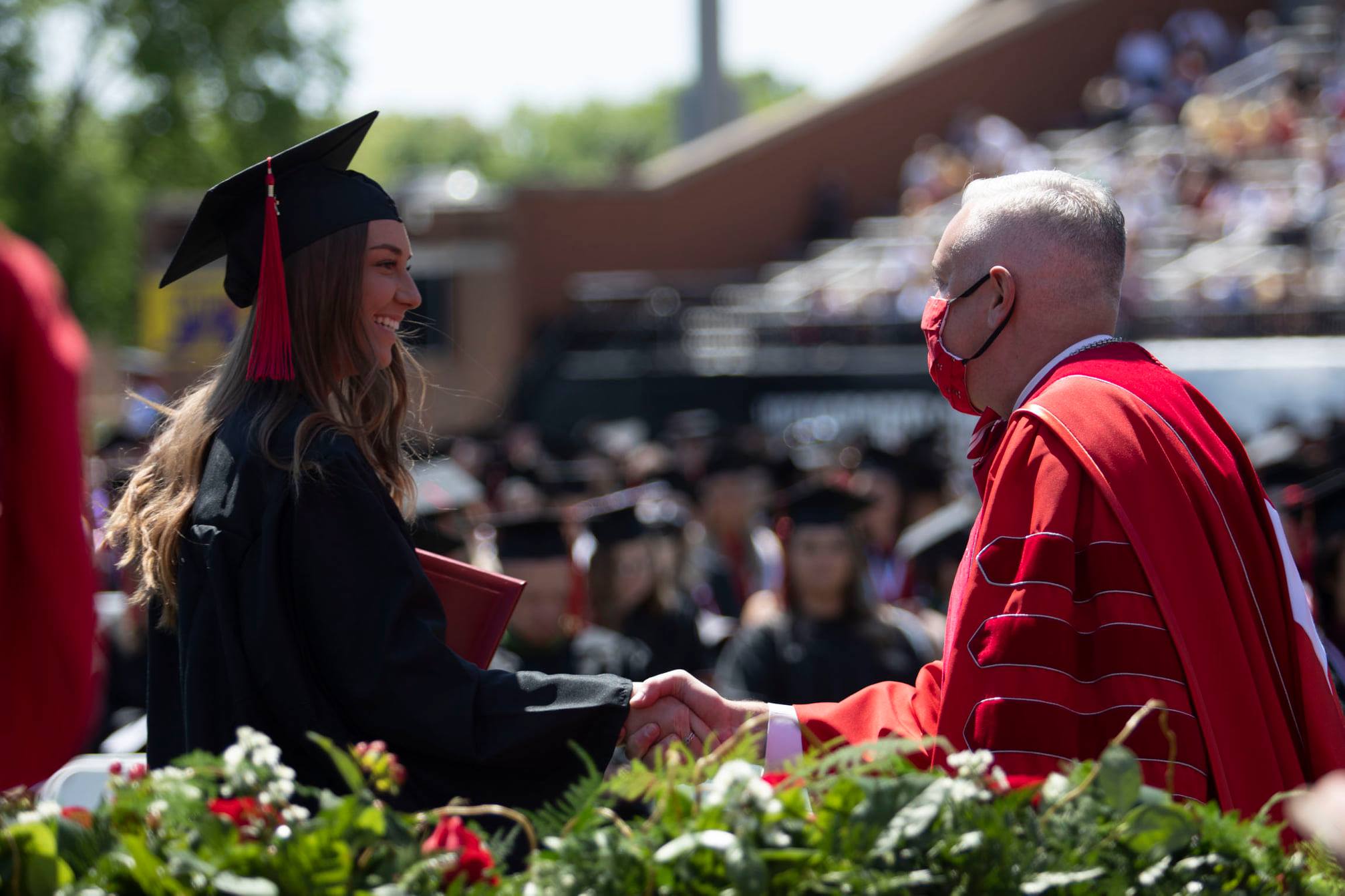 caboni shaking hands with a graduate
