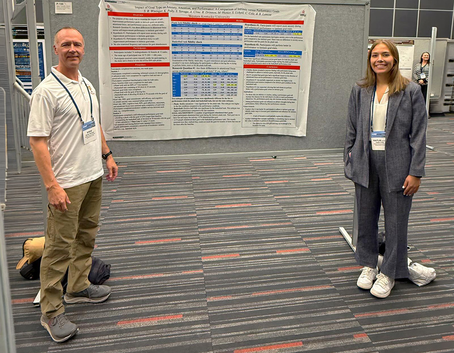 A WKU faculty member and student presenting research at a conference.