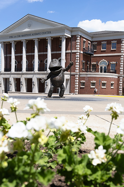 flowers and statue of big red in front of the martens alumni center at wku