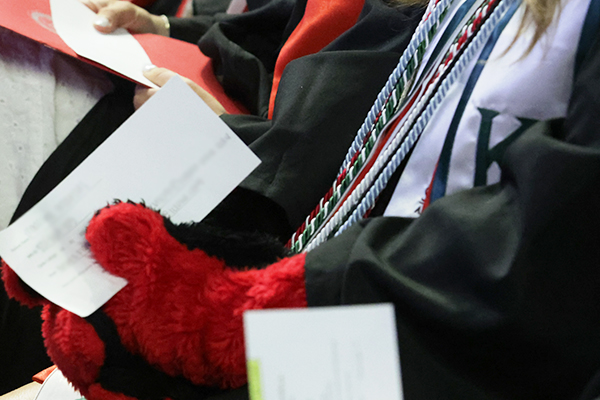 Reader card held in the glove of a graduate wearing Big Red hands