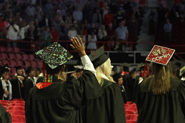 WKU graduate waving to crowd WKU graduate waving to crowd with a decorated cap stating star of the show