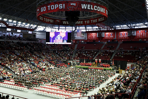 Graduates seated on the arena floor during College Recognition Ceremonies