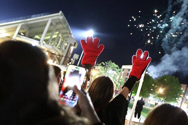 graduates posing for photos near fireworks display at big red bash