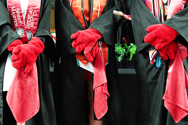 graduates wearing big red gloves holding wku red towels