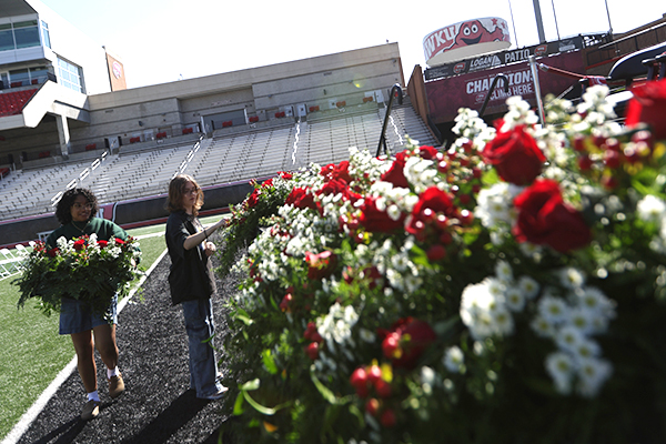Students arrange flowers on the Commencement stage before the event