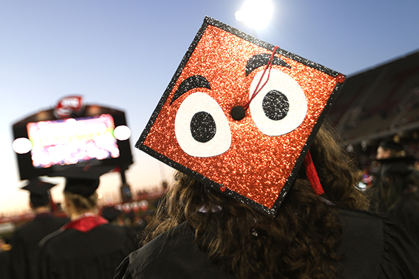 graduate wearing a cap with design of glitter big red eyes