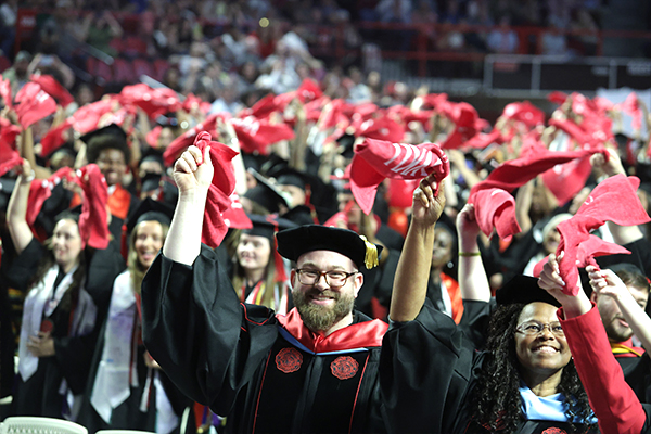 graduates wave red towels at graduation ceremony