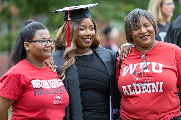 graduate surrounded by family members who are wearing WKU and WKU alumni shirts