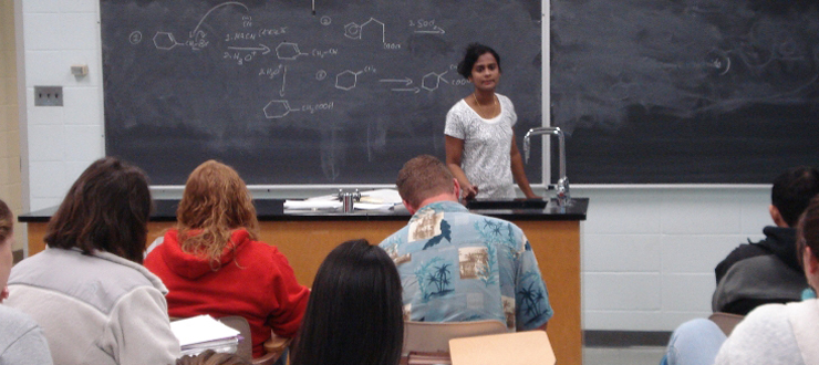A WKU faculty member teaching in front of a blackboard