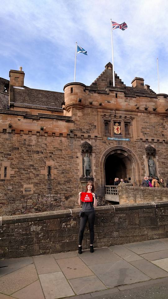 Gilliam holding WKU red towel in front of a castle in the UK