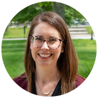 image of woman wearing a burgundy blazer and wearing glasses