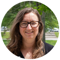 image of woman with brown hair, glasses, and black blazer