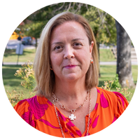 woman with short blonde hair and an orange dress