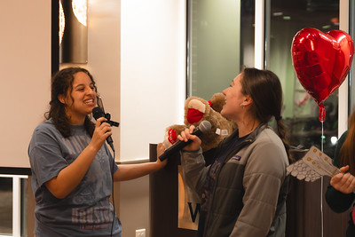 two young women karaoke singing into a microphone