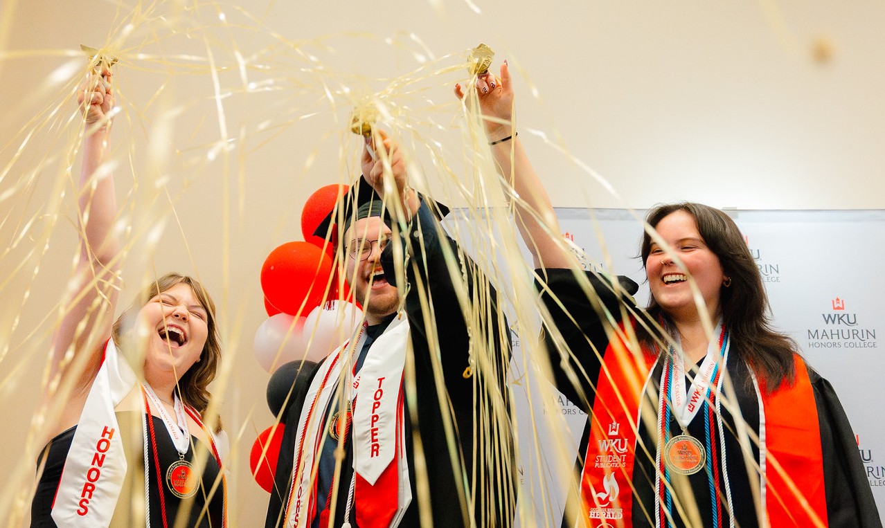 trio of graduates throwing confetti