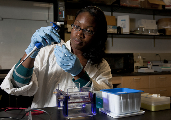 young black woman scientist measuring liquid chemicals