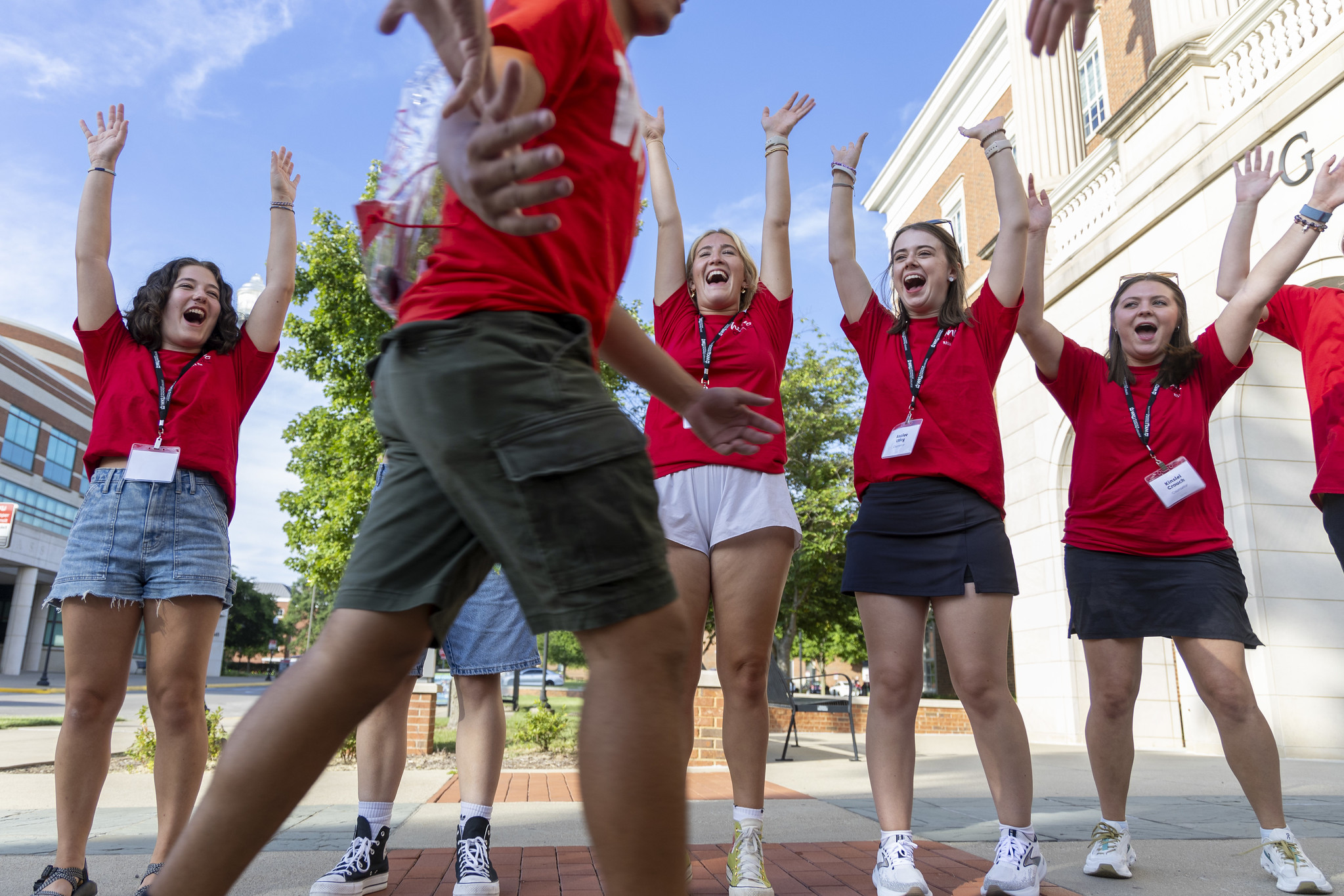 group of students in WKU shirts cheering on a student entering