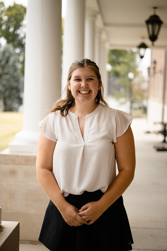 College student smiling at camera in fancy clothes