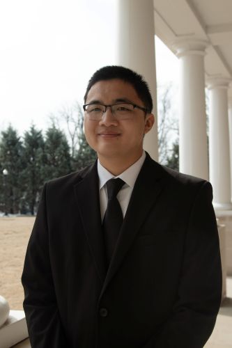 young asian man in a suit smiling
