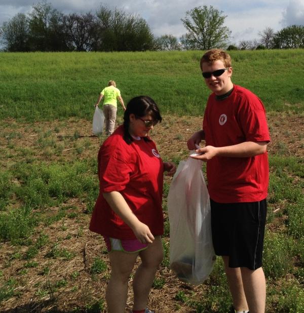 two volunteers loading bag with trash