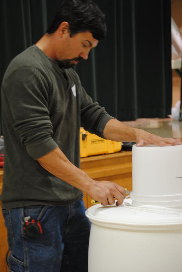 John marks the size of hole to cut for inserting the bucket