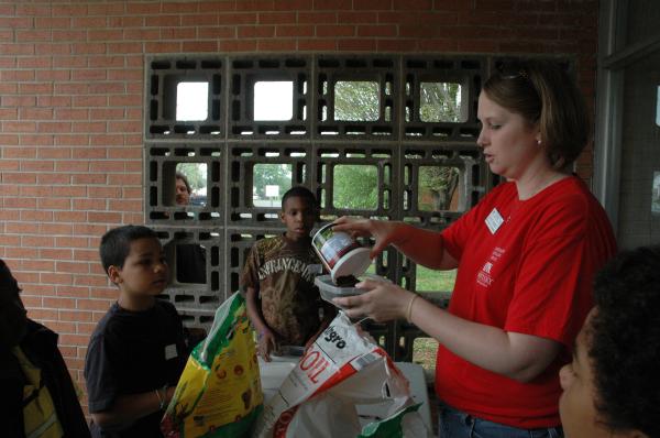 Julie demonstrates how to plant tomato seeds