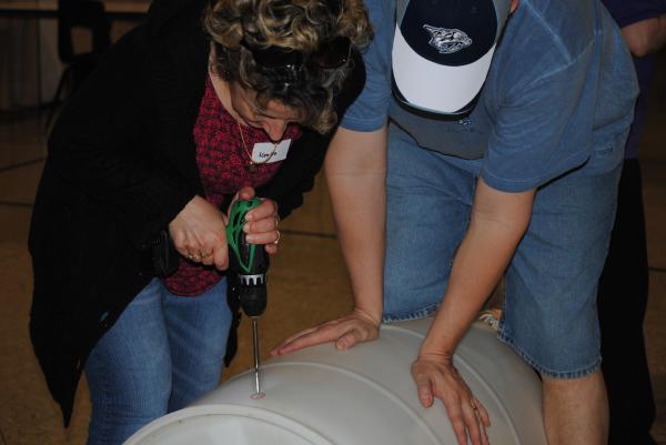 Mother drills hole for spigot.