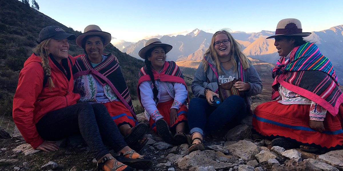 Holly Case and Danielle Dorsey interact with indigenous women in Peru during their Semester at Sea experience.