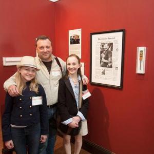 View Tim Broekema, with his daughters Kacey and Gabi, stand before his display in the exhibit. He was a picture editor in Louisville when the newspaper editorial staff won a Pulitzer Prize for team coverage of the Carrollton, Ky bus crash. Larger
