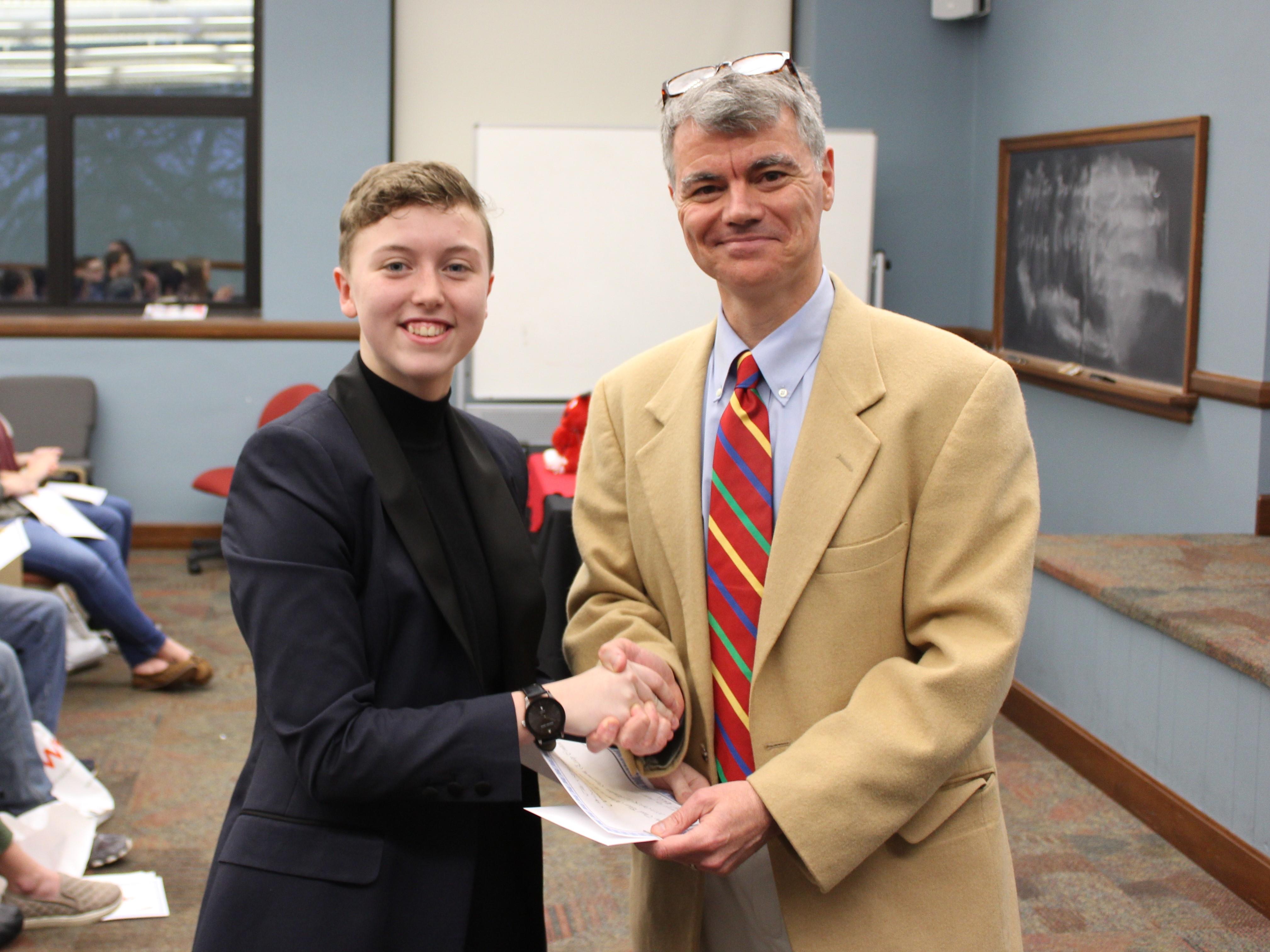 Dr. Hale shaking hands with 3rd place winner in Creative Writing, Shelby Beaty