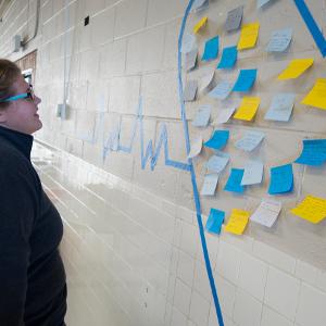 View Participant reading the "PAH moments" posted on a wall Larger