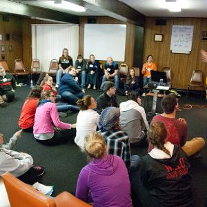 View Group of participants sitting in a circle in a workshop Larger