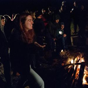 View Participants standing around bonfire Larger