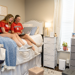Two female students sitting on the bed in Regents Hall