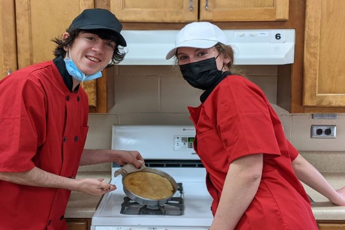 Two students show off what they baked in the HMD kitchen.