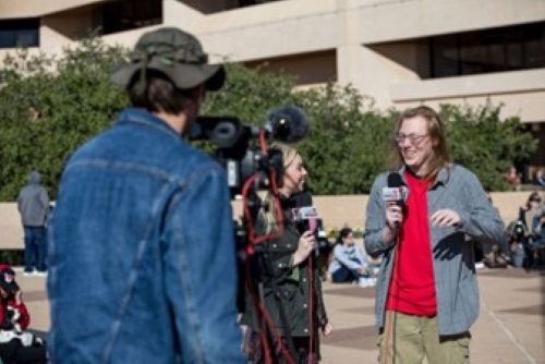 WKU student Travis Peden (right) takes a break from writing app code to provide an on-air narrative to an Odessa, TX TV station during the October 14 annular eclipse (Clinton Lewis/WKU)
