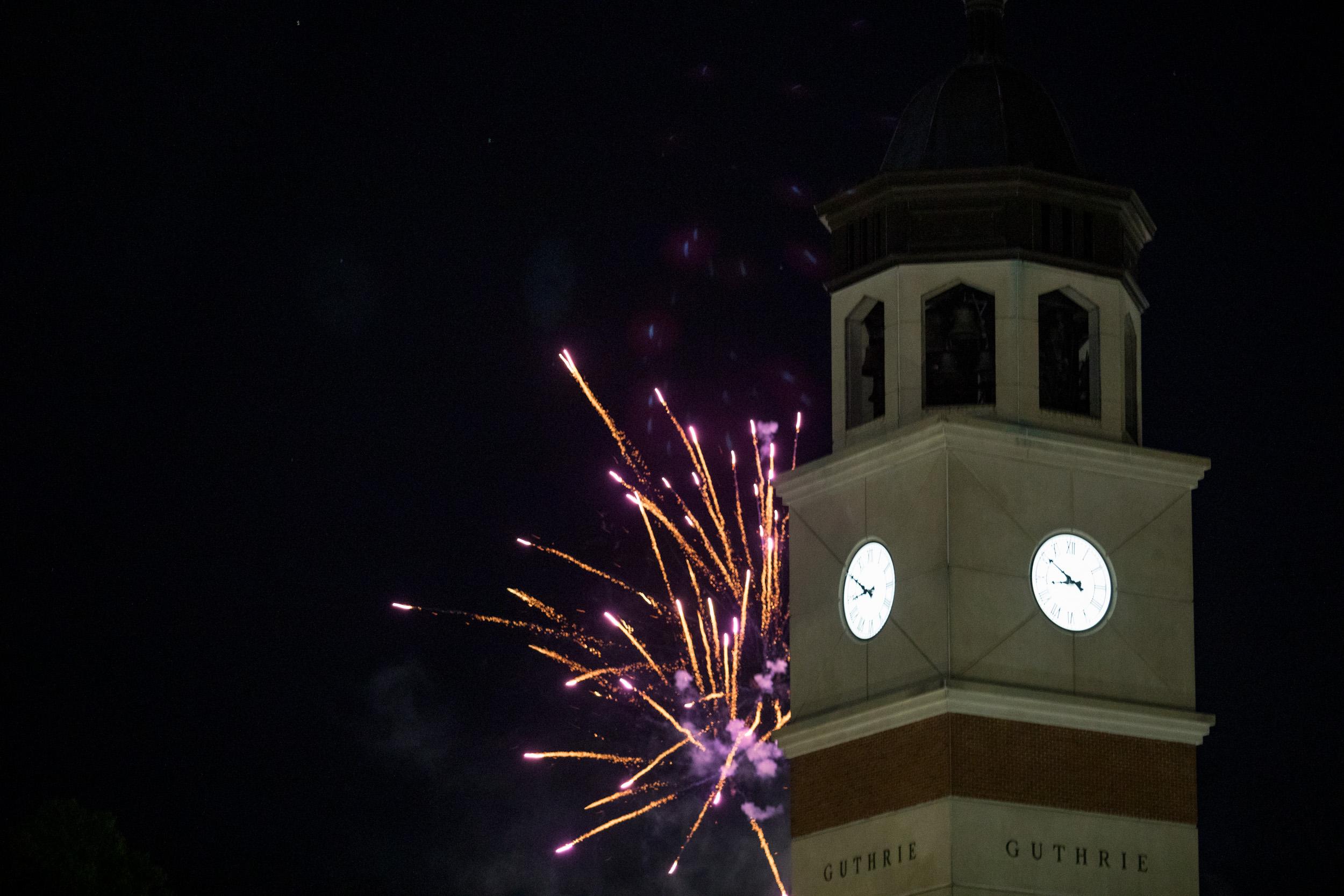 Firework burst behind Guthrie Bell Tower during Topper Fest