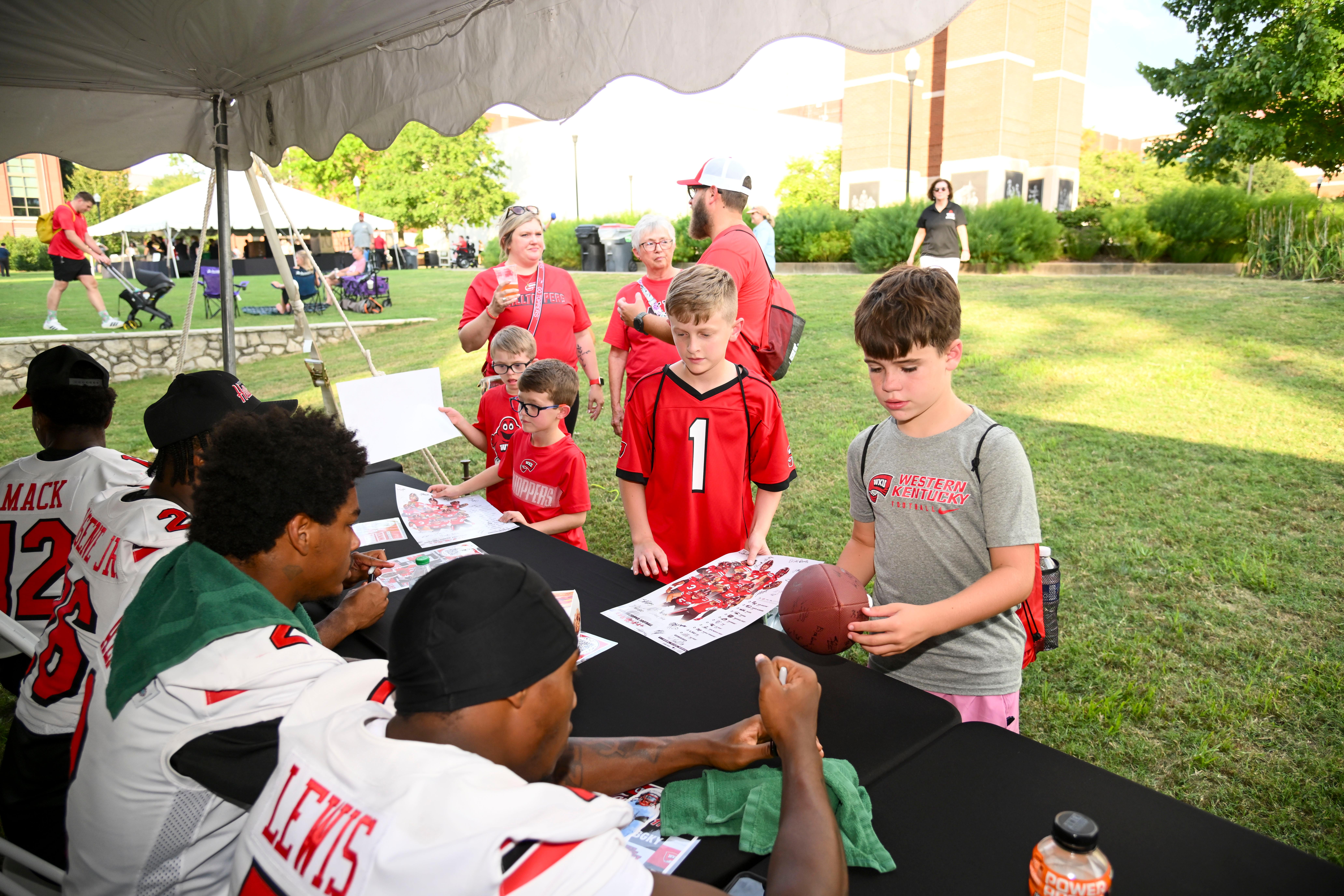 WKU student-athletes signing autographs at Topper Fest