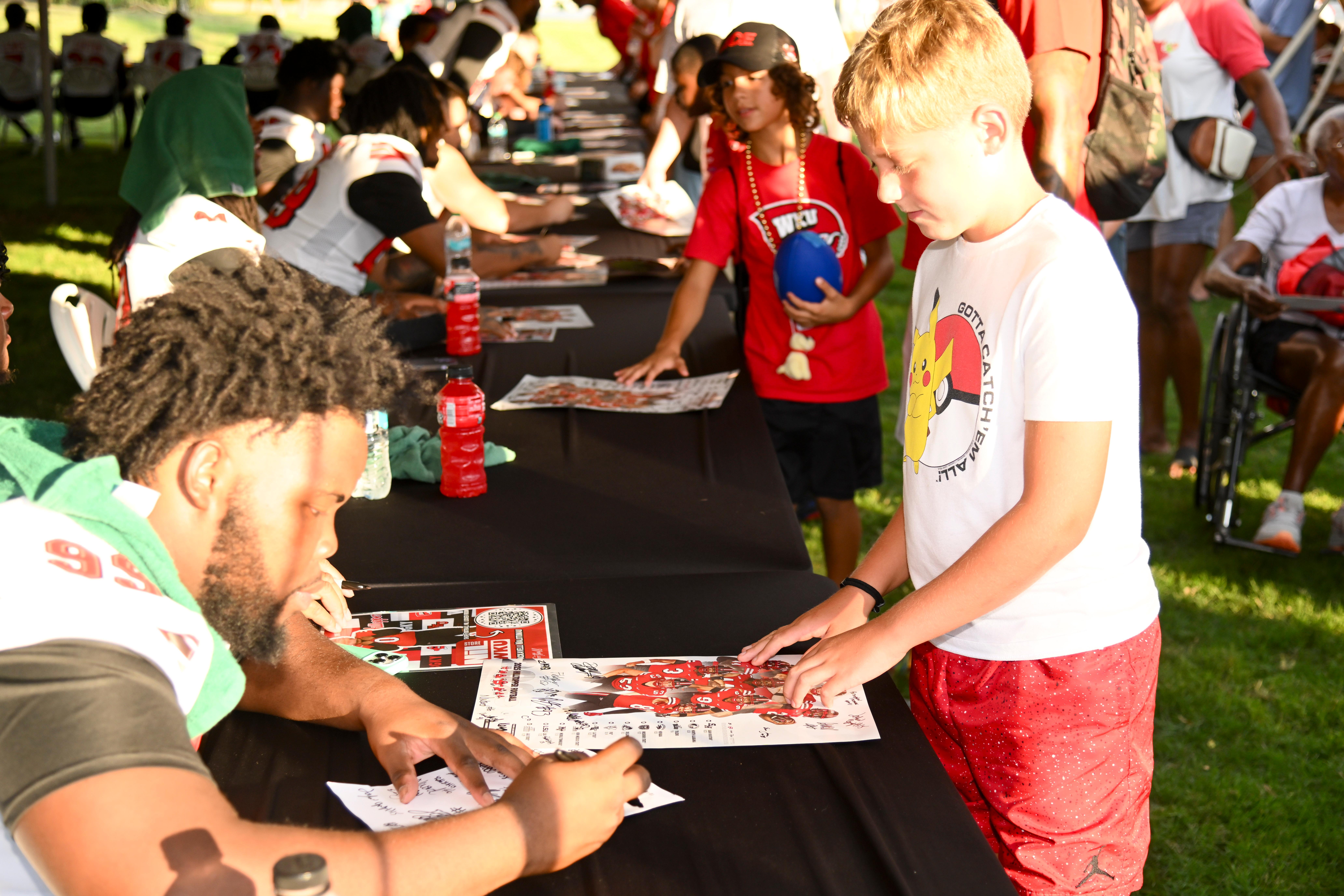 WKU student-athletes signing autographs at Topper Fest