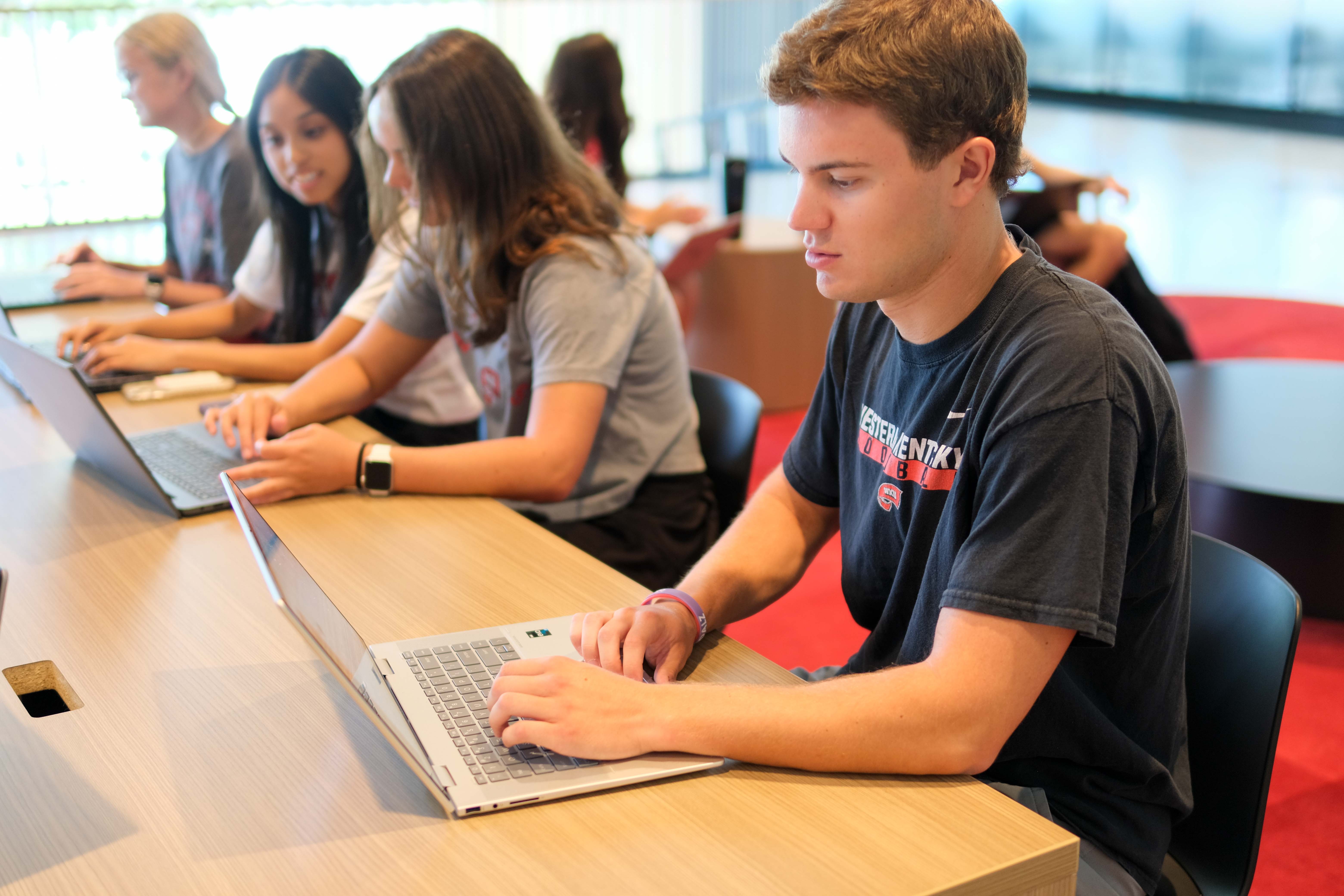 A Western Kentucky University student raises her hand in class.