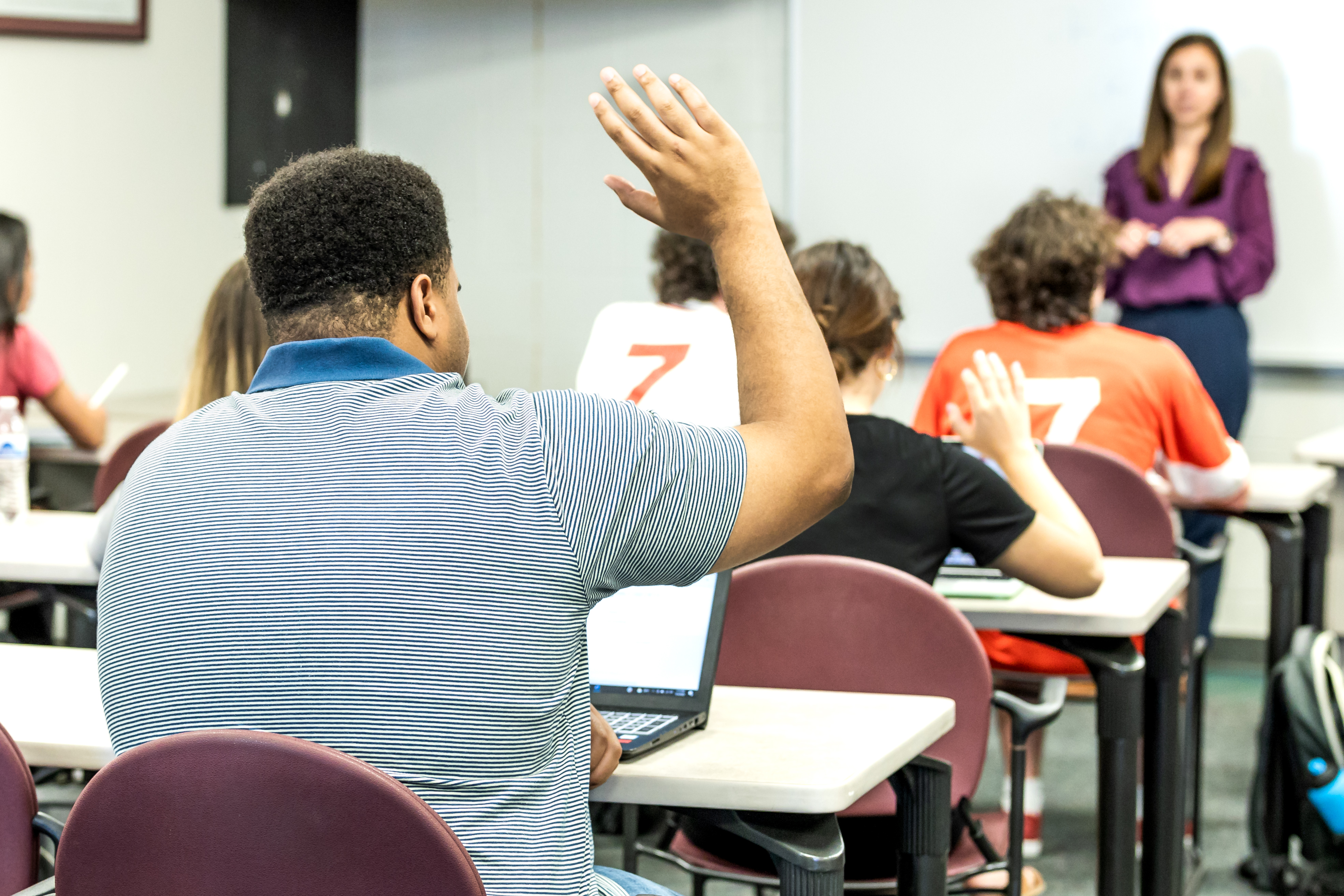 Student raises their hand in class.