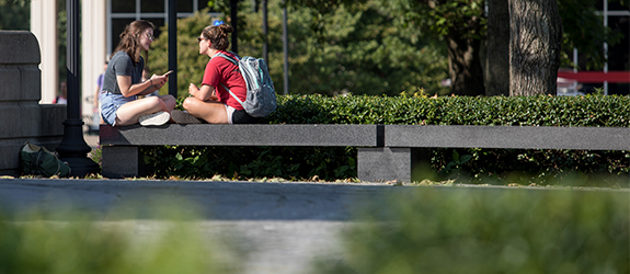 two students sitting and talking on WKU's campus