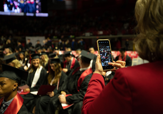 Person taking a photo at graduation on their phone