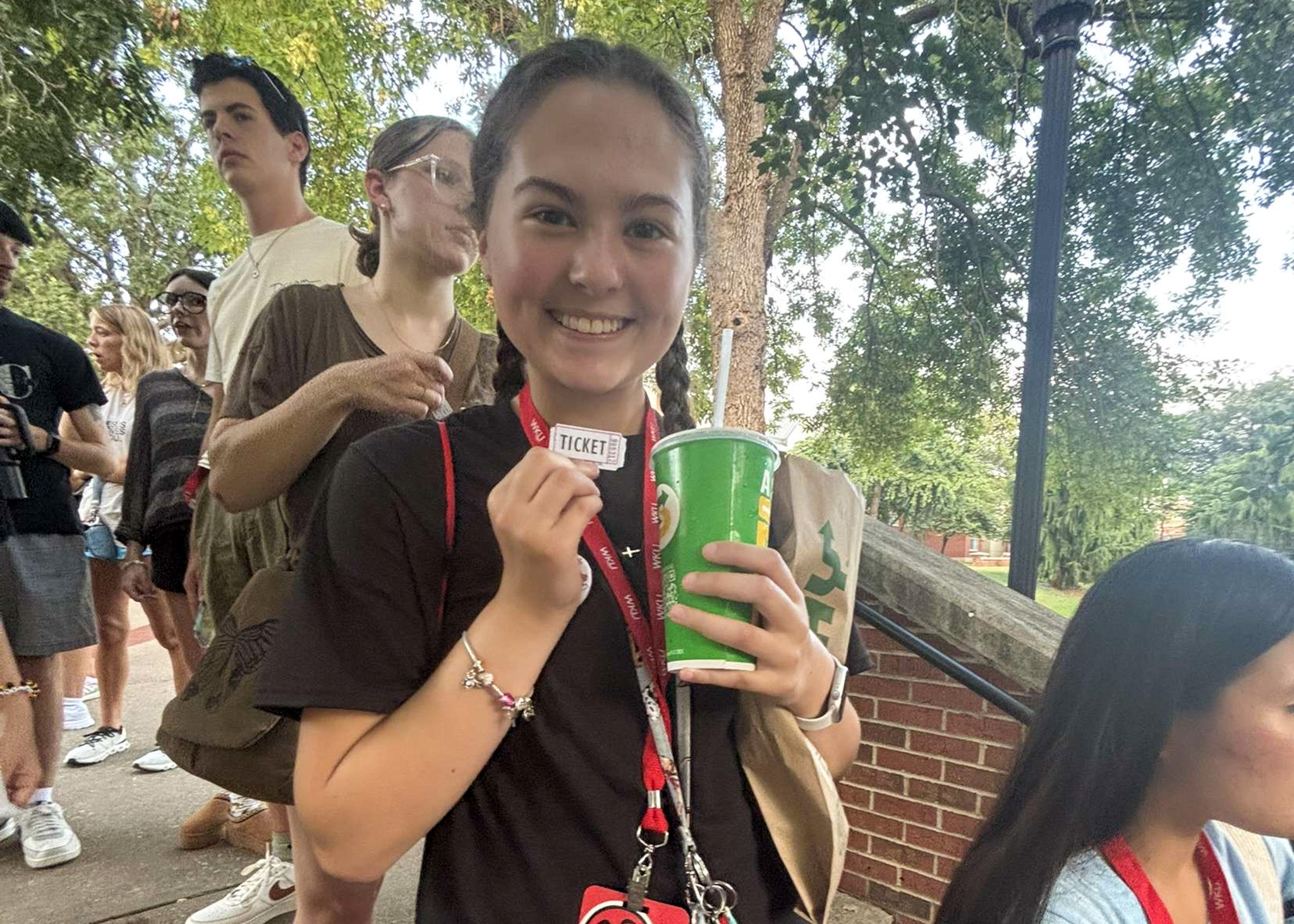 Photo of woman smiling with ticket in hand